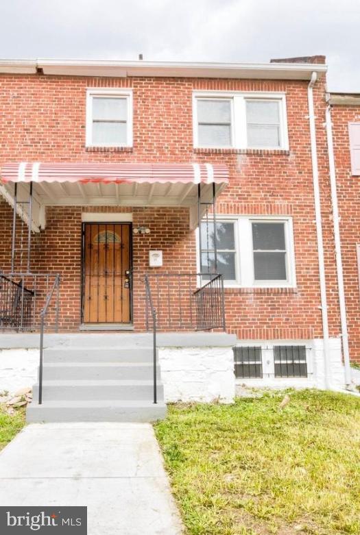 multi unit property featuring a front yard and covered porch