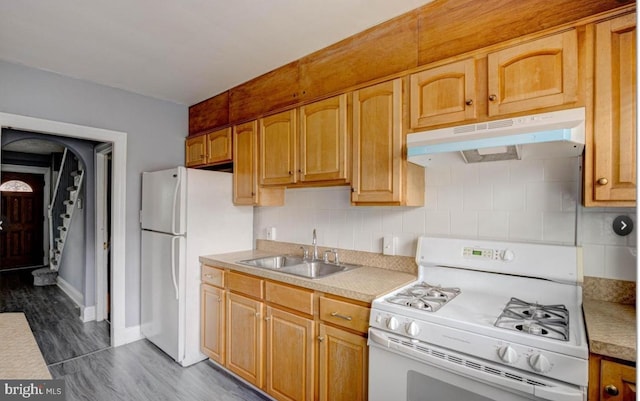 kitchen with sink, white appliances, dark wood-type flooring, and backsplash