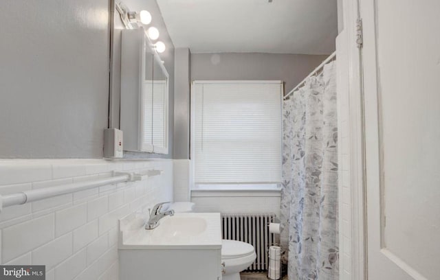 bathroom with vanity, toilet, radiator, and tile walls