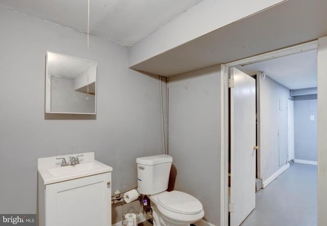 bathroom with vanity, toilet, and concrete flooring