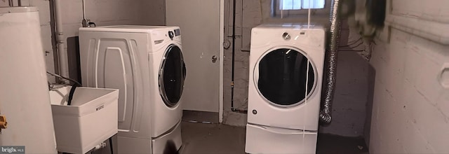 clothes washing area with washing machine and dryer and sink