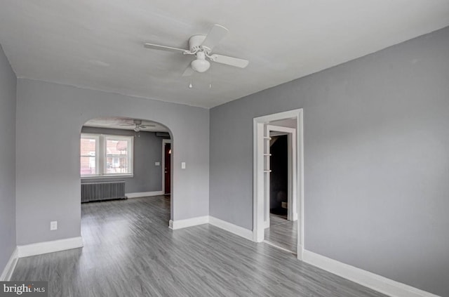 spare room featuring radiator, ceiling fan, and light hardwood / wood-style floors