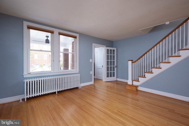 foyer entrance featuring radiator heating unit and light hardwood / wood-style flooring