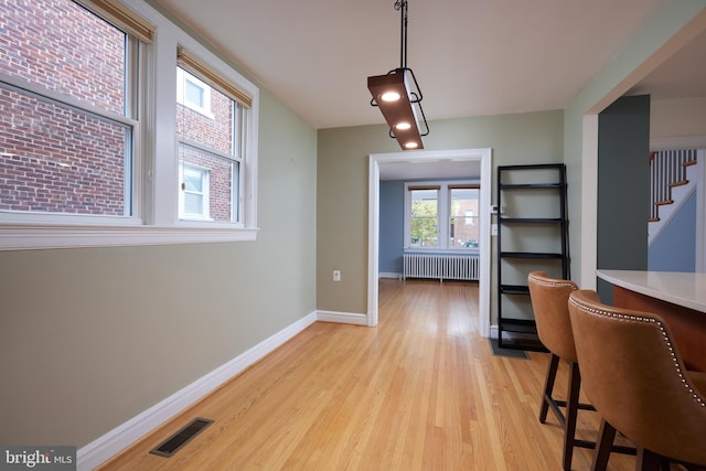 526 Powhatan Pl NW, Washington, DC 20011 - dining room with radiator, light wood finished floors, baseboards, and stairway
