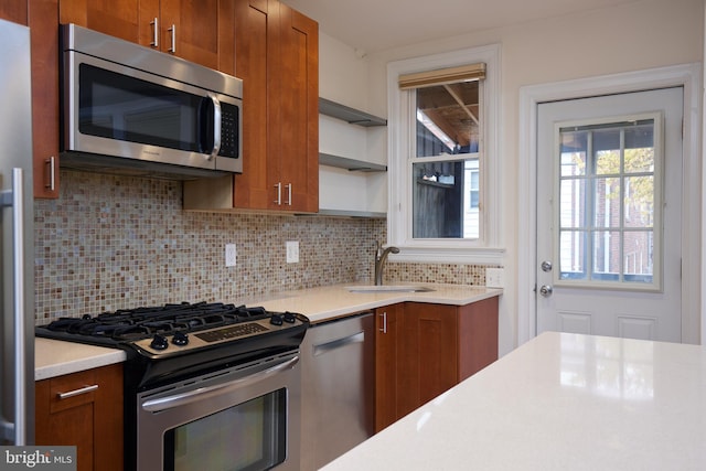 526 Powhatan Pl NW, Washington, DC 20011 - kitchen featuring stainless steel appliances, a sink, brown cabinetry, light countertops, and tasteful backsplash