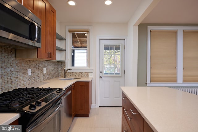 kitchen featuring backsplash, light tile patterned floors, sink, and appliances with stainless steel finishes