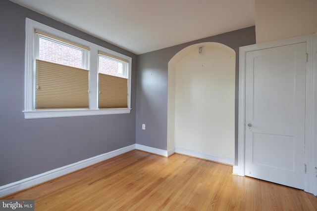 526 Powhatan Pl NW, Washington, DC 20011 - empty room featuring arched walkways, light wood-style floors, and baseboards
