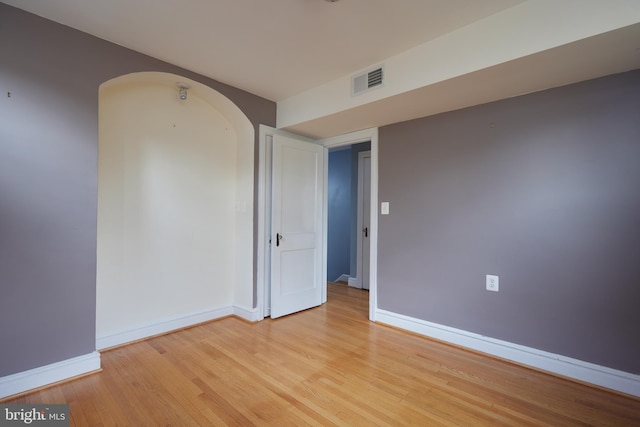 526 Powhatan Pl NW, Washington, DC 20011 - spare room with arched walkways, light wood-style floors, and baseboards