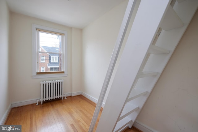 empty room with hardwood / wood-style flooring and radiator