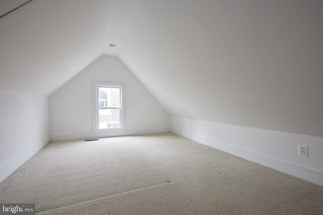 bonus room with light carpet and lofted ceiling