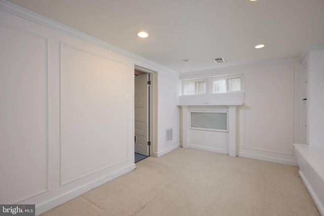 unfurnished living room featuring ornamental molding and light carpet