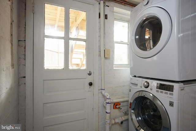 clothes washing area featuring stacked washer and clothes dryer