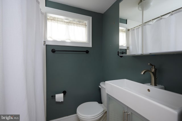 526 Powhatan Pl NW, Washington, DC 20011 - bathroom with toilet, vanity, baseboards, and a shower with shower curtain