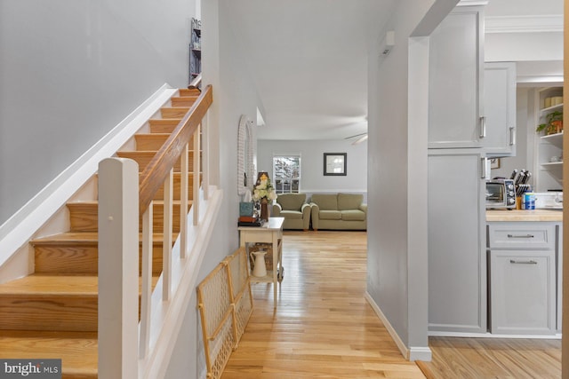 stairs featuring ceiling fan and wood-type flooring