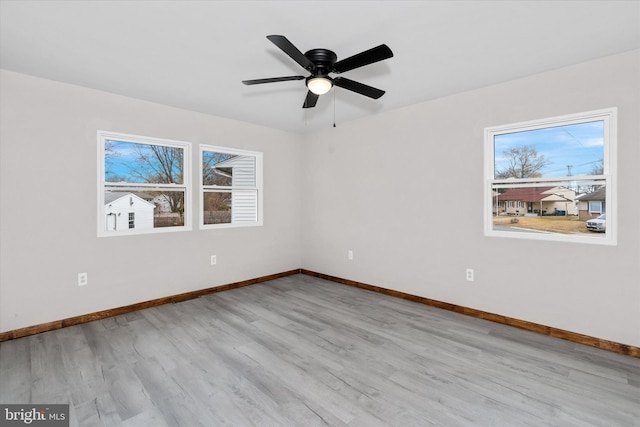 empty room featuring light hardwood / wood-style floors, a wealth of natural light, and ceiling fan