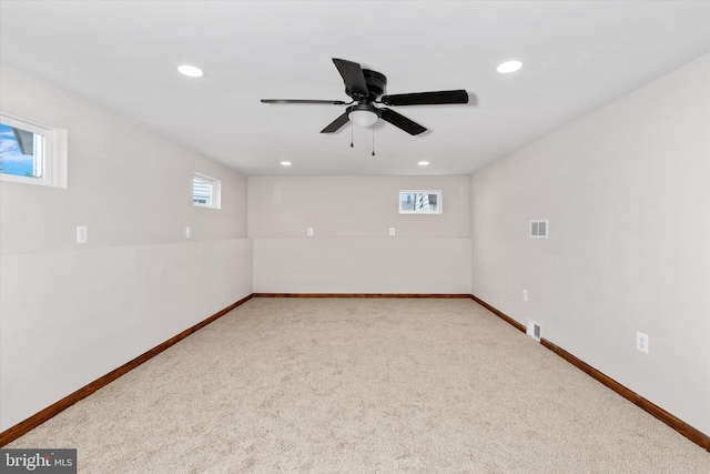 carpeted spare room with ceiling fan and plenty of natural light