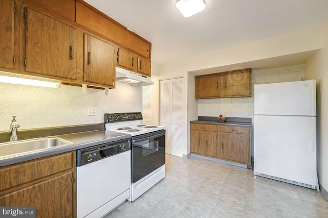 kitchen featuring decorative backsplash, white appliances, and sink