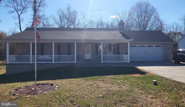 ranch-style house featuring covered porch, a front yard, and a garage