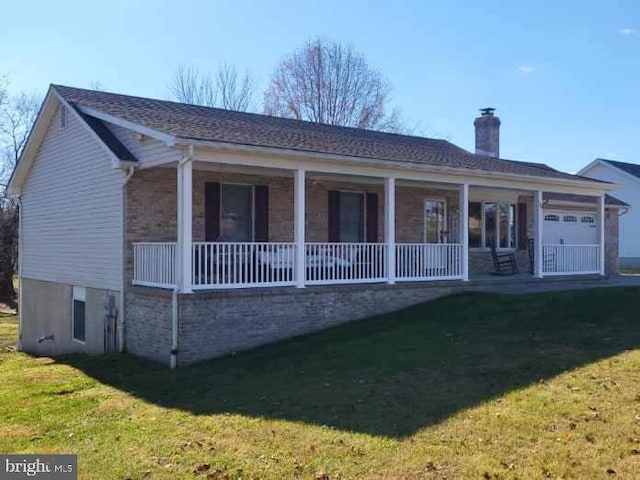 view of front facade with a porch, a front yard, and a garage