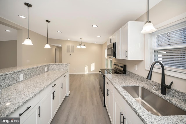 kitchen with stainless steel appliances, light stone counters, and sink