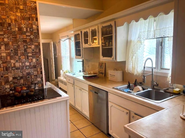 kitchen featuring dishwasher, white cabinetry, light tile patterned flooring, and sink