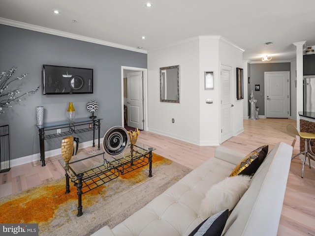 living room with crown molding and light hardwood / wood-style flooring