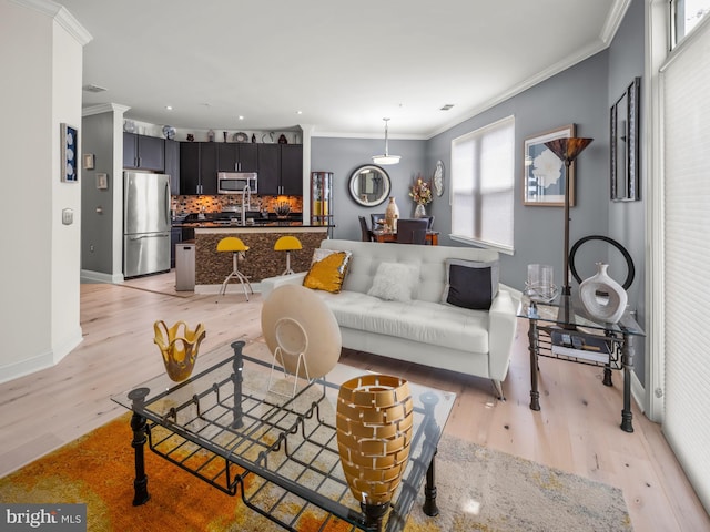 living room featuring light wood-type flooring and ornamental molding