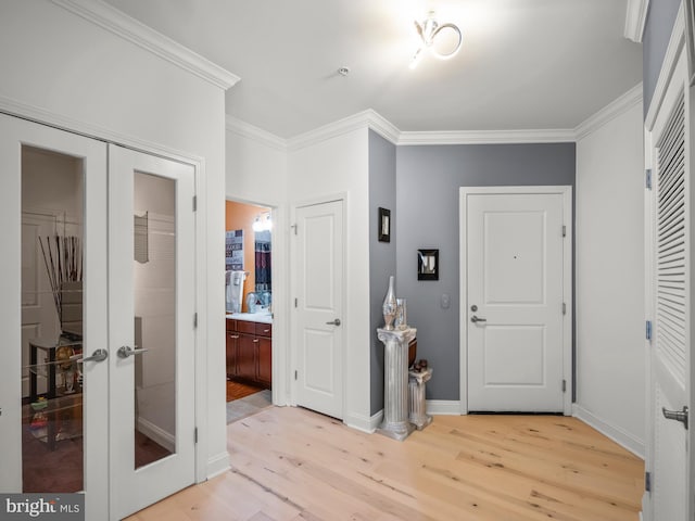 foyer with crown molding, french doors, and light hardwood / wood-style floors