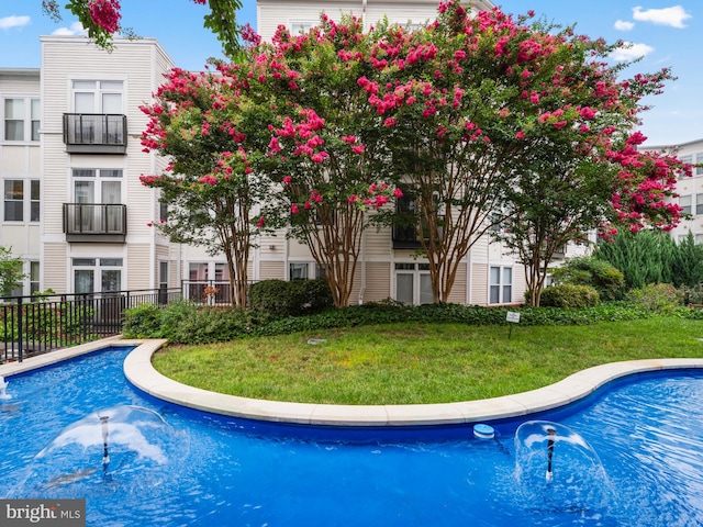 view of swimming pool featuring a lawn