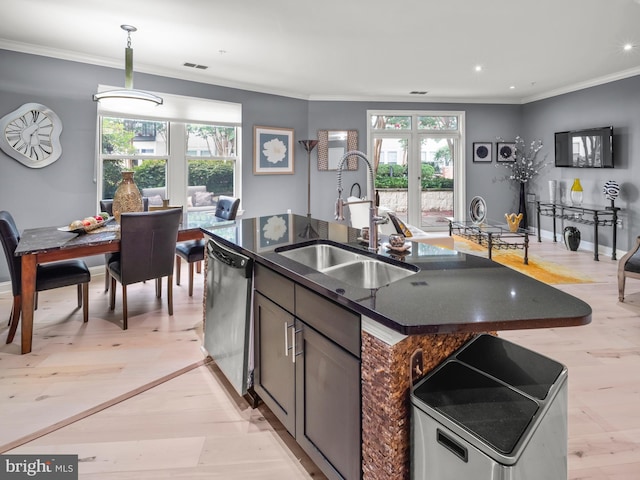 kitchen featuring a center island with sink, stainless steel dishwasher, a healthy amount of sunlight, and sink