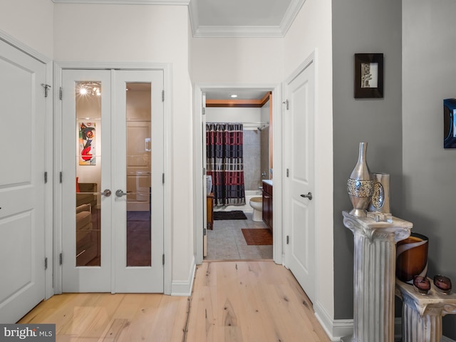 hallway with french doors, light hardwood / wood-style flooring, and ornamental molding