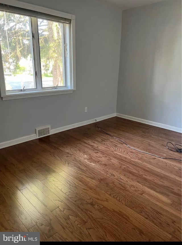 spare room featuring dark wood-type flooring