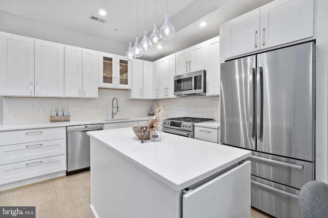 kitchen with a center island, appliances with stainless steel finishes, sink, and white cabinets