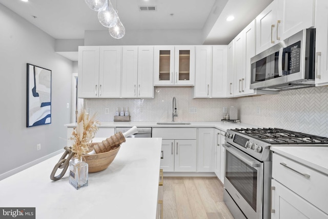 kitchen featuring white cabinetry, stainless steel appliances, sink, and decorative backsplash