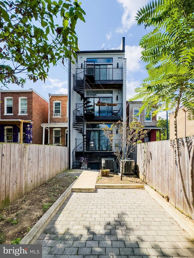 rear view of house with central AC unit and a patio