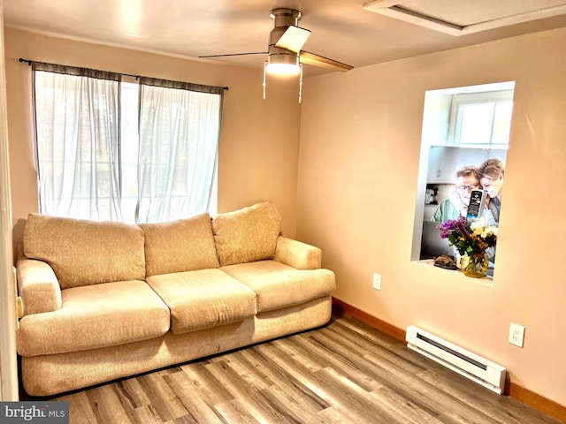 living room featuring ceiling fan, wood-type flooring, and baseboard heating