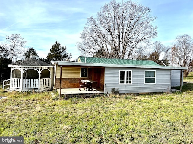 back of property with a gazebo and a yard