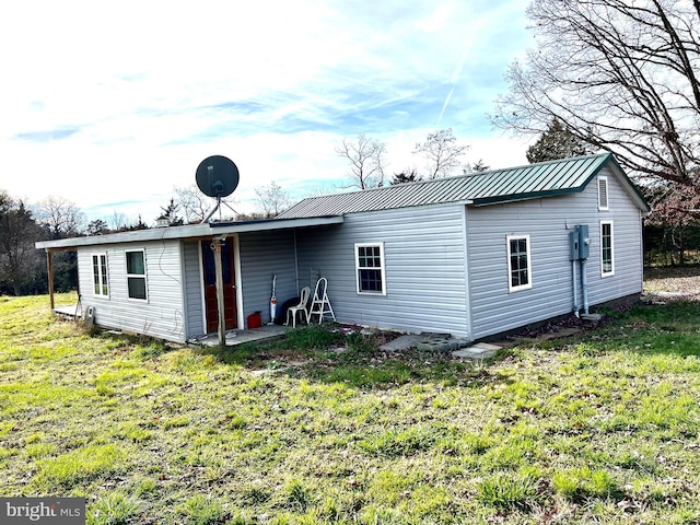 rear view of property featuring a lawn