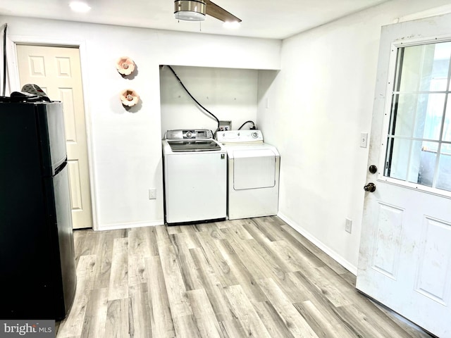 clothes washing area featuring washer and clothes dryer and light hardwood / wood-style floors