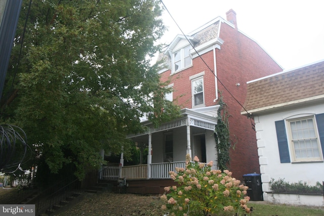 view of side of property with a porch