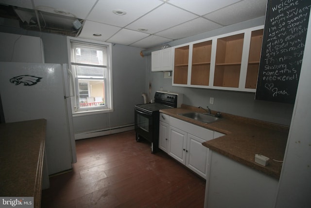 kitchen with white fridge, black range with electric stovetop, white cabinetry, and sink