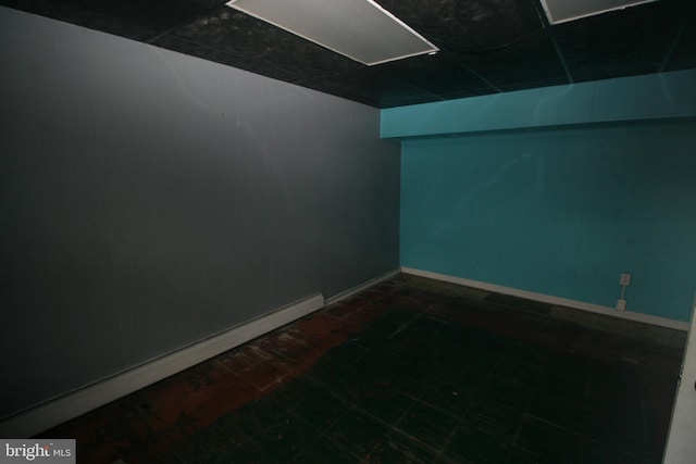 empty room with a drop ceiling and baseboard heating