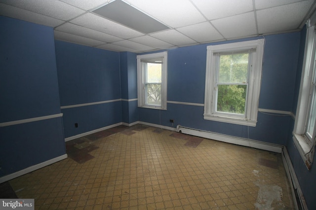 empty room with a paneled ceiling and a baseboard radiator