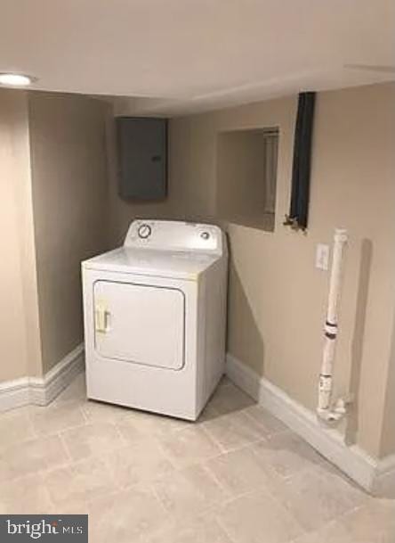 clothes washing area featuring electric panel, light tile patterned floors, and washer / dryer