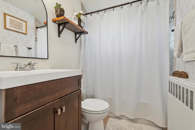 bathroom featuring vanity, toilet, and radiator