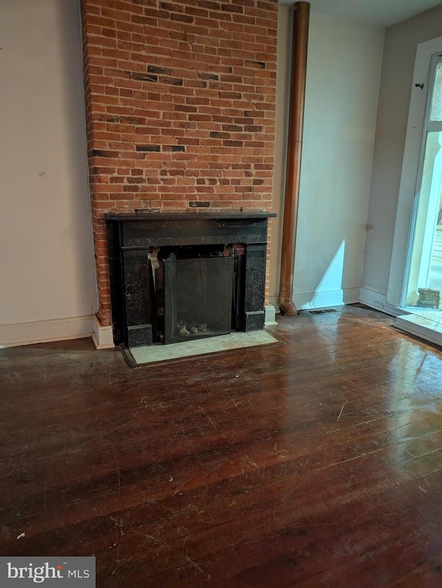 interior details featuring hardwood / wood-style floors and a large fireplace