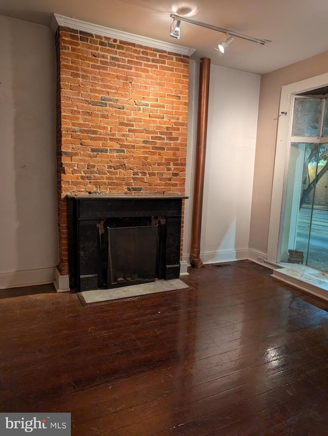 interior space featuring a fireplace, wood-type flooring, track lighting, and crown molding