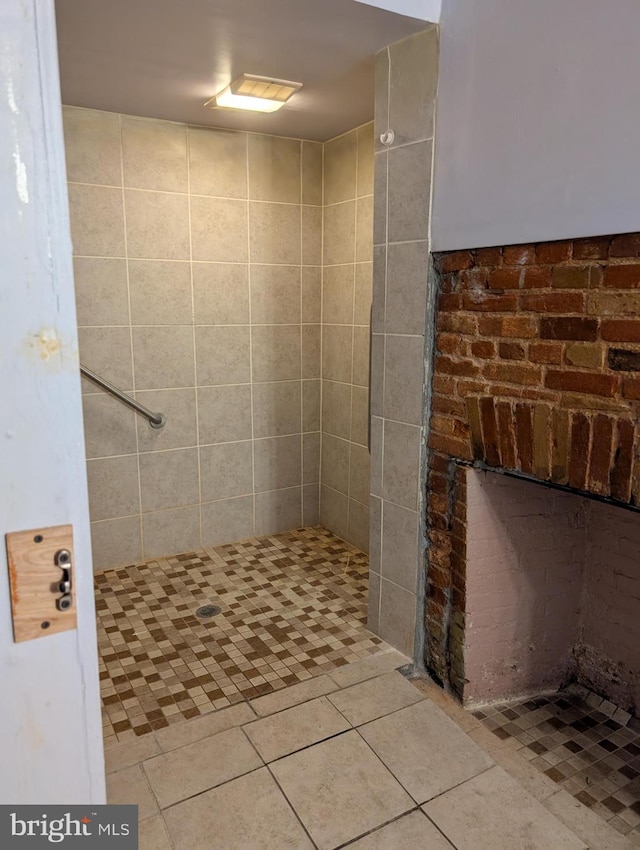 bathroom with tile patterned floors and tiled shower