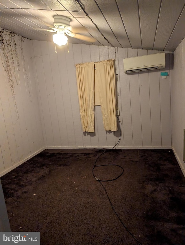 unfurnished room with wooden walls, ceiling fan, a wall mounted air conditioner, and dark colored carpet