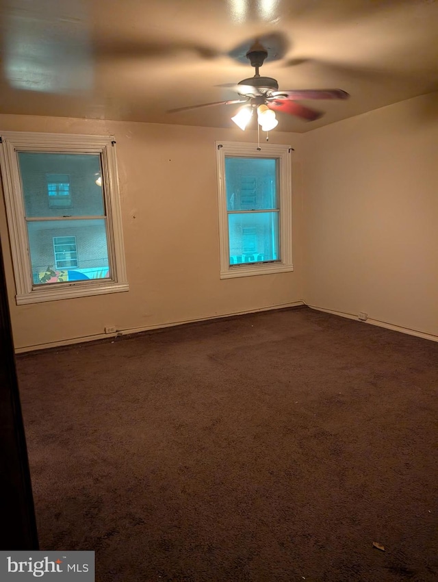 unfurnished room featuring dark carpet and ceiling fan